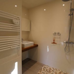 Salle de bain moderne dun hébergement insolite en Bourgogne, avec douche et carrelage élégant.