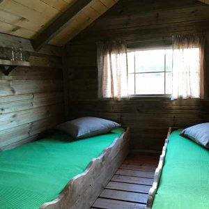 Cabane en bois à Île-de-France avec lits simples et fenêtres lumineuses.