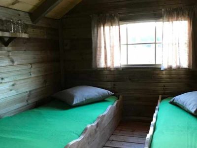 Cabane en bois à Île-de-France avec lits simples et fenêtres lumineuses.