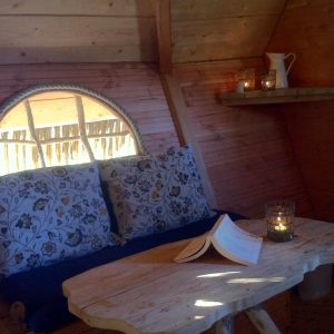 Cabane cosy en Île-de-France, avec un coin lecture et des coussins fleuris.