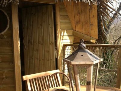 Cabane perchée en Île-de-France avec terrasse en bois et lanternes décoratives.
