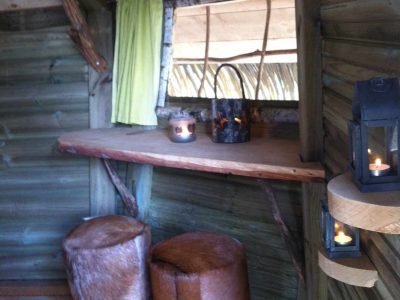 Cabane insolite en Île-de-France avec tabourets en peau et ambiance chaleureuse.