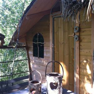 Cabane perchée en bois à lIle-de-France, avec des lanternes en tronc darbre.
