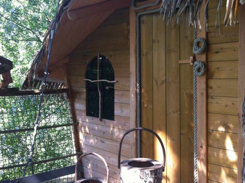 Cabane perchée en bois à lIle-de-France, avec des lanternes en tronc darbre.