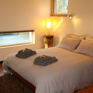 Chambre cosy dans un hébergement insolite en Bourgogne, vue sur la rivière.