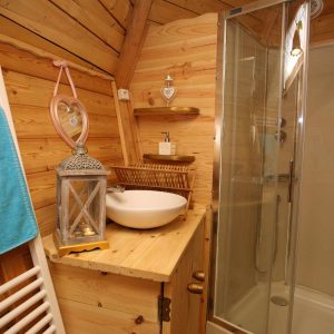 Cabane en bois dans les Hauts-de-France, avec salle de bain moderne et décor chaleureux.