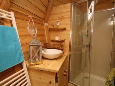 Cabane en bois dans les Hauts-de-France, avec salle de bain moderne et décor chaleureux.