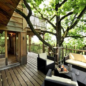 Cabane dans les arbres en Midi-Pyrénées, avec terrasse en bois et vue sur la nature.