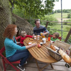 Cabane dans les arbres en Hauts-de-France, famille profitant dun petit déjeuner en plein air.
