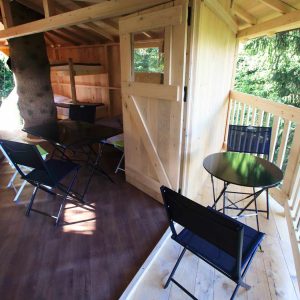 Cabane en bois perchée, avec mobilier moderne et vue sur la nature environnante.