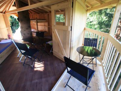 Cabane en bois perchée, avec mobilier moderne et vue sur la nature environnante.