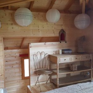 Chalet en bois à Aquitaine, avec lanternes suspendues et mobilier en bois naturel.