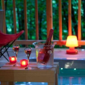 Hébergement insolite en Limousin : jacuzzi, champagne et bougies créent une ambiance romantique.