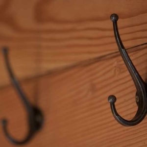 Hébergement insolite en bois avec crochets décoratifs sur un mur chaleureux.