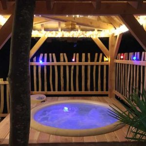 Cabane perchée en Île-de-France avec jacuzzi et éclairage féerique.