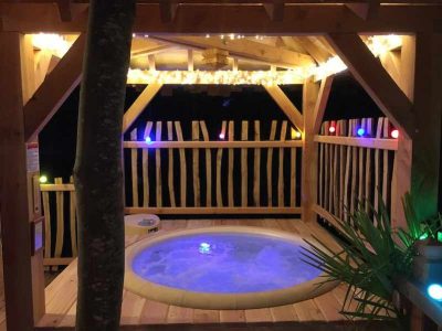 Cabane perchée en Île-de-France avec jacuzzi et éclairage féerique.