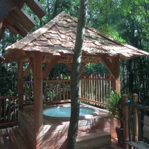 Hébergement insolite en Île-de-France avec jacuzzi en bois sous un abri naturel.
