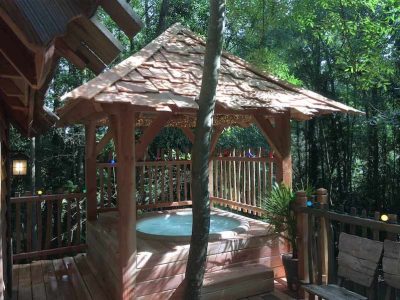 Hébergement insolite en Île-de-France avec jacuzzi en bois sous un abri naturel.