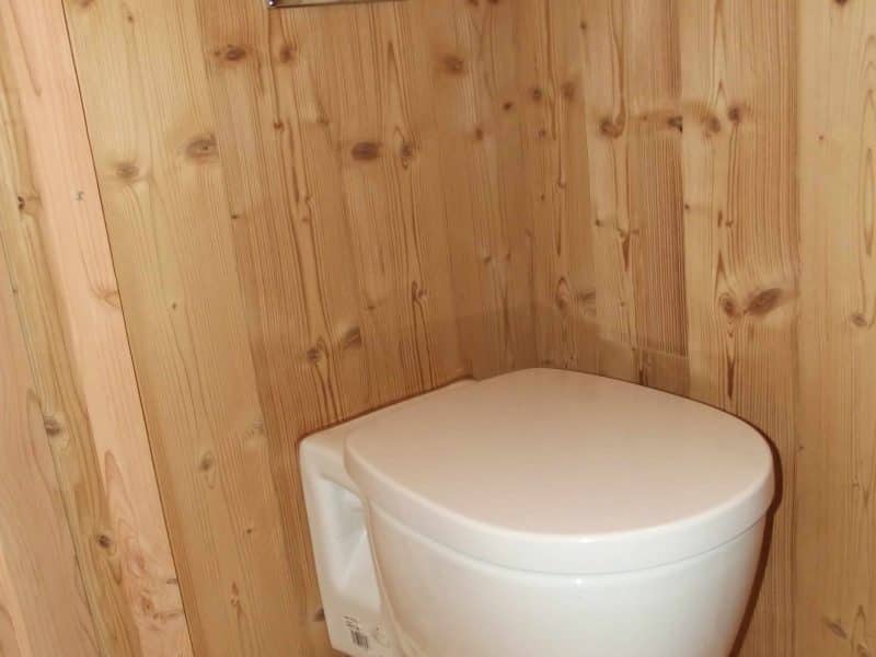 Toilettes modernes dans un hébergement en bois, ambiance chaleureuse et naturelle.