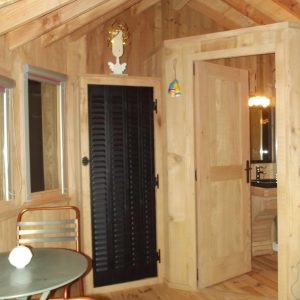 Cabane en bois à Bourgogne-Franche-Comté, intérieur chaleureux avec meubles en métal.