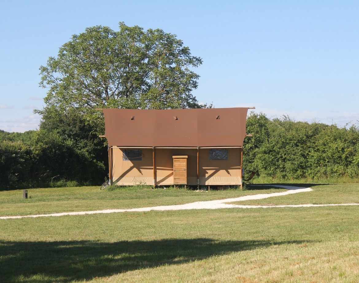 Hébergement insolite en toile, avec une structure originale et un chemin en gravier.