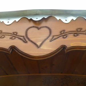 Hébergement insolite en bois avec un joli motif en forme de cœur sur le toit.