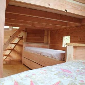 Cabane en bois avec lits superposés et ambiance chaleureuse en Centre.