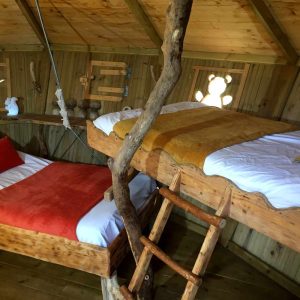 Cabane perchée en Bourgogne avec lits en bois et décoration chaleureuse.