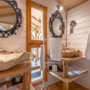 Salle de bain dun hébergement insolite en Aquitaine avec lavabos en bois naturel.
