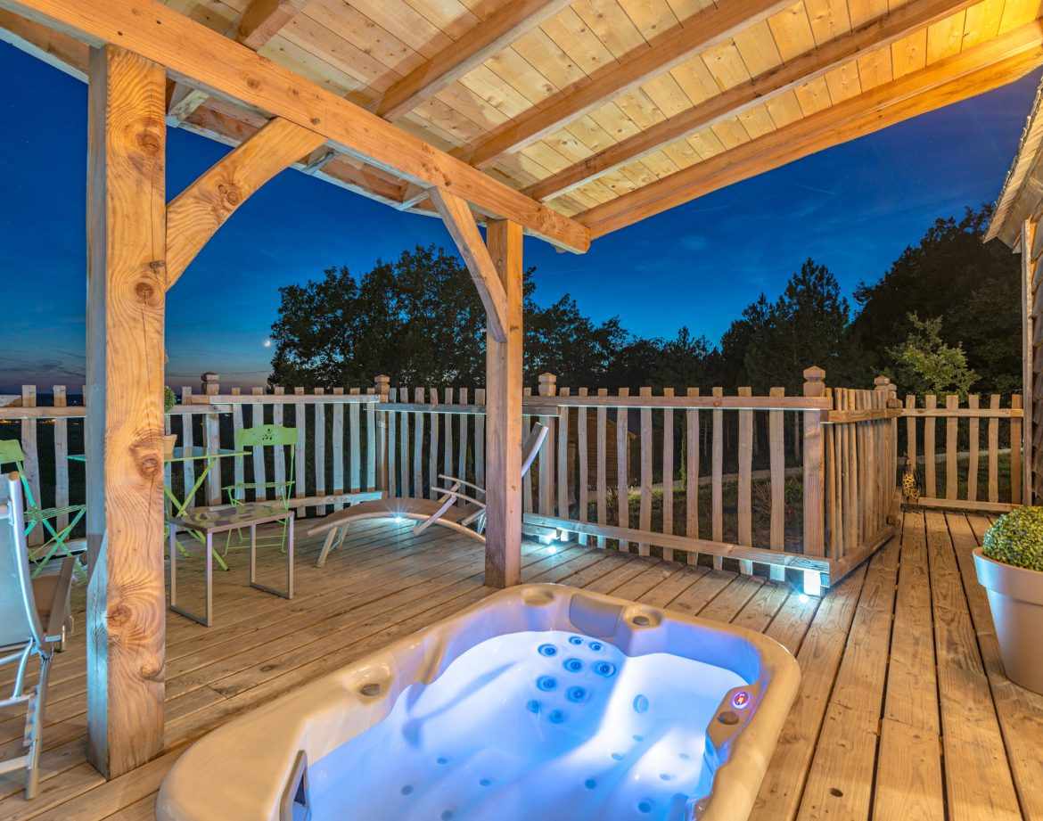 Hébergement insolite en Aquitaine avec jacuzzi sur une terrasse en bois.