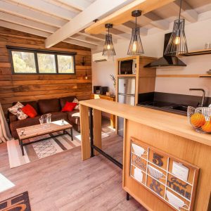 Cottage moderne en bois avec cuisine ouverte et décoration chaleureuse en Aquitaine.