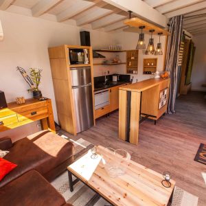 Hébergement insolite en Aquitaine : intérieur moderne avec cuisine en bois et lumière naturelle.