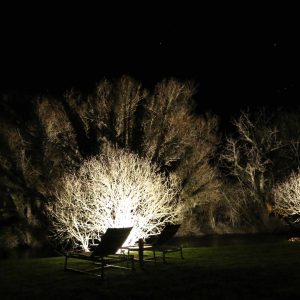 Hébergement insolite en Bourgogne : chaises longues illuminées sous un ciel étoilé.