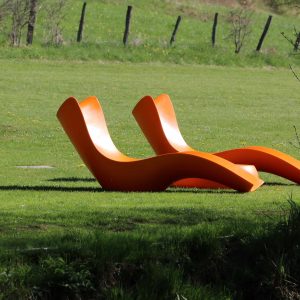 Chaises longues orange sur une pelouse verdoyante, hébergement insolite en Bourgogne.