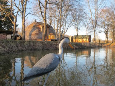 Hébergement insolite en forme de dôme au bord de leau, entouré darbres.