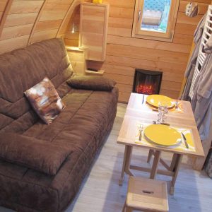 Hébergement insolite en bois à Champagne-Ardenne, avec un coin salon cosy et cheminée.