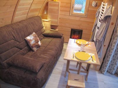 Hébergement insolite en bois à Champagne-Ardenne, avec un coin salon cosy et cheminée.