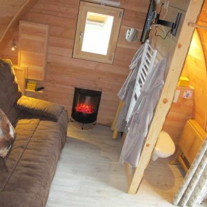 Hébergement insolite en bois à Champagne-Ardenne, avec un coin salon confortable et cheminée.