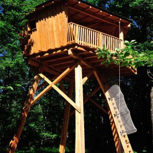 Cabane perchée en bois, entourée darbres, offrant une vue imprenable sur la nature.