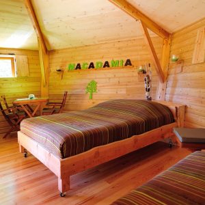 Chalet en bois chaleureux avec lit double et décoration naturelle à Auvergne-Rhône-Alpes.