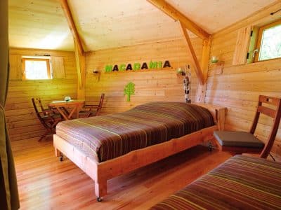 Chalet en bois chaleureux avec lit double et décoration naturelle à Auvergne-Rhône-Alpes.