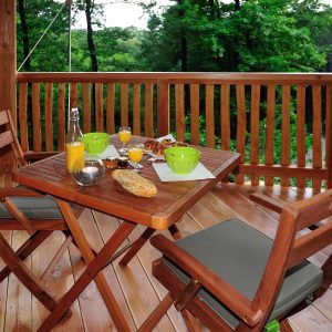 Terrasse en bois dun hébergement insolite avec vue sur la nature verdoyante.