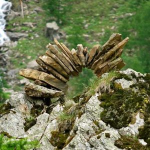 Hébergement insolite en pleine nature, avec une sculpture en bois sur un rocher.
