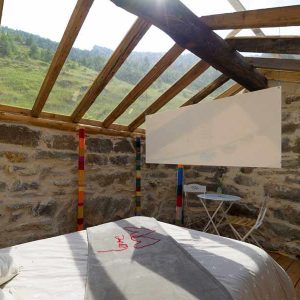 Chalet en bois avec toit en verre, offrant une vue imprenable sur les montagnes.