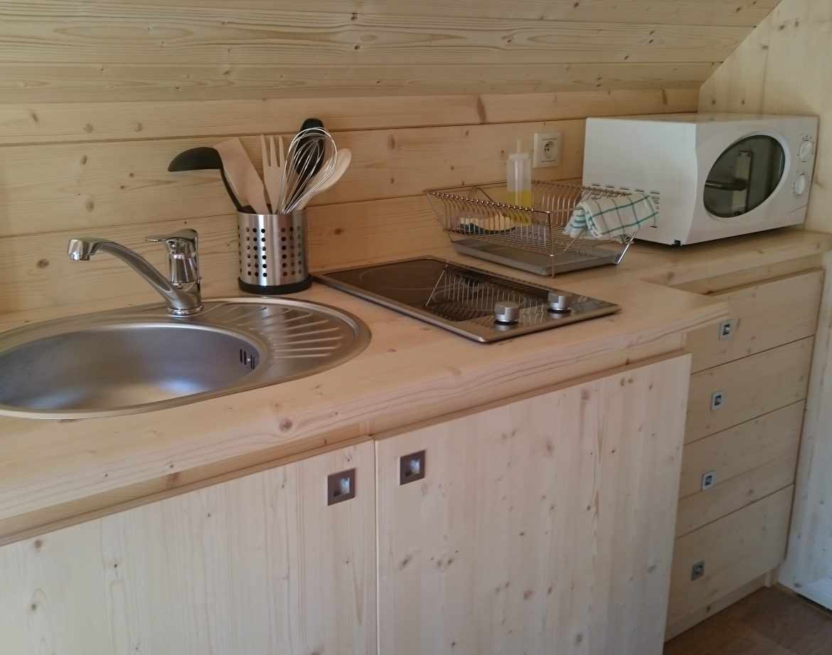 Hébergement insolite en bois avec cuisine équipée et ambiance chaleureuse.