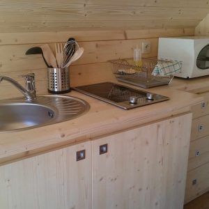 Hébergement insolite en bois avec cuisine équipée et ambiance chaleureuse.