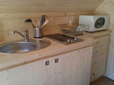 Hébergement insolite en bois avec cuisine équipée et ambiance chaleureuse.
