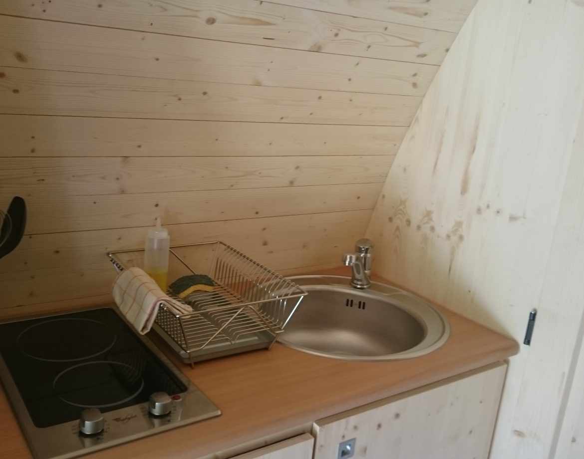 Hébergement insolite en bois avec cuisine équipée et ambiance chaleureuse.