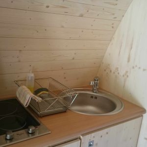 Hébergement insolite en bois avec cuisine équipée et ambiance chaleureuse.