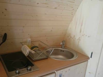 Hébergement insolite en bois avec cuisine équipée et ambiance chaleureuse.